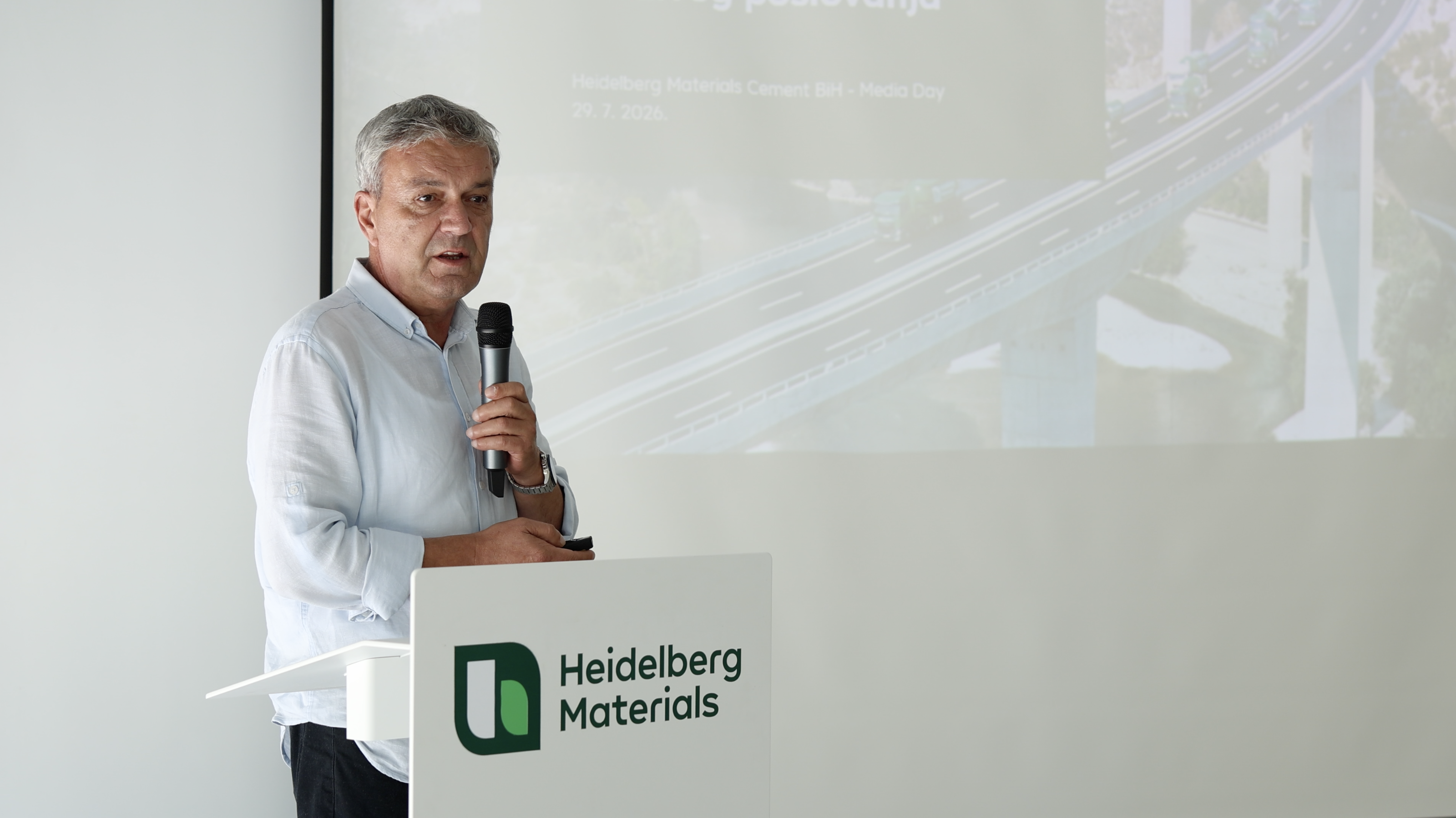 Muškarac drži mikrofon i prezentira na događaju kompanije Heidelberg Materials.