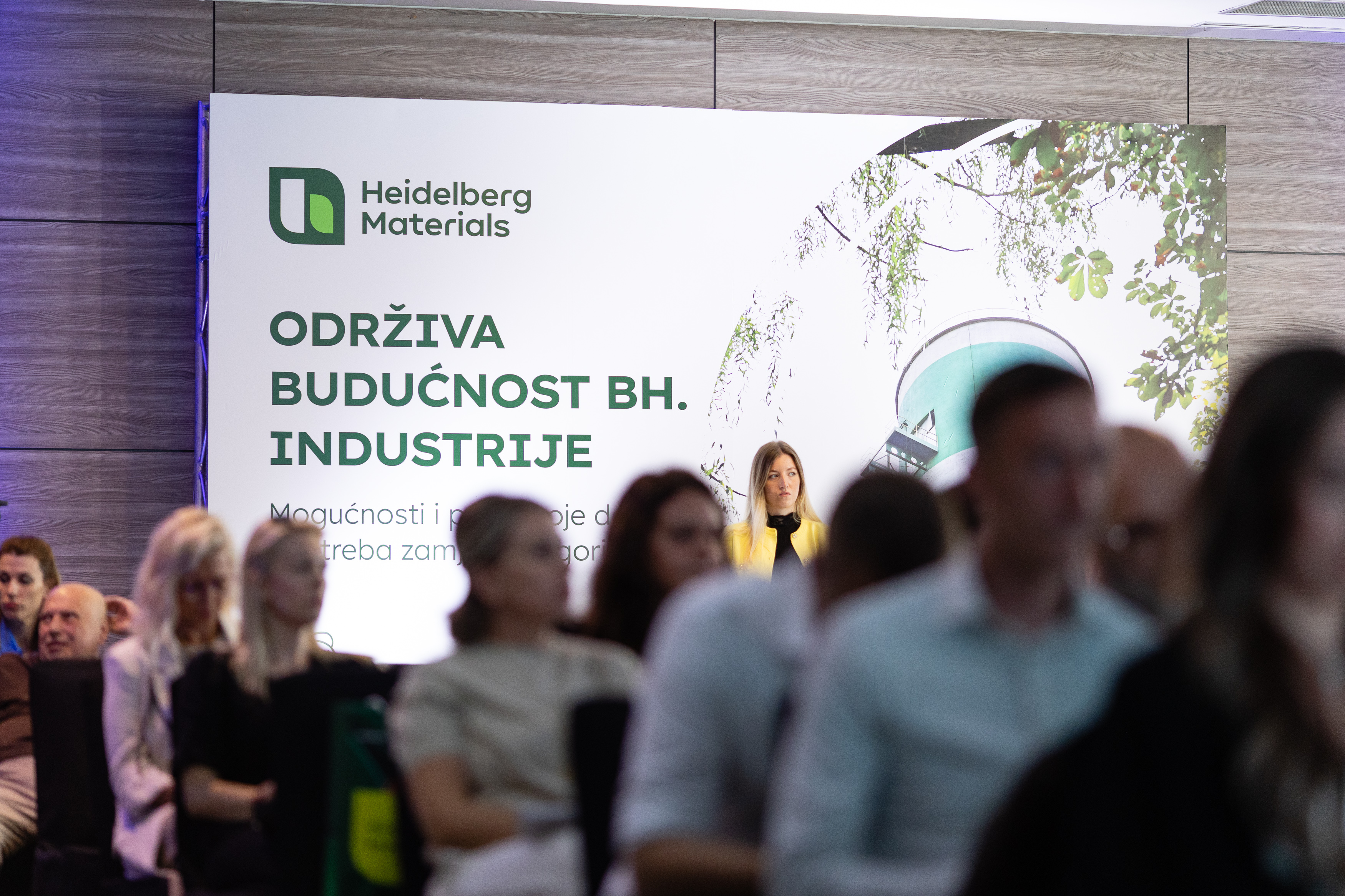 Prikaz konferencije s učesnicima, ispred postera s logotipom Heidelberg Materials i natpisom "Održiva budućnost BH. industrije".