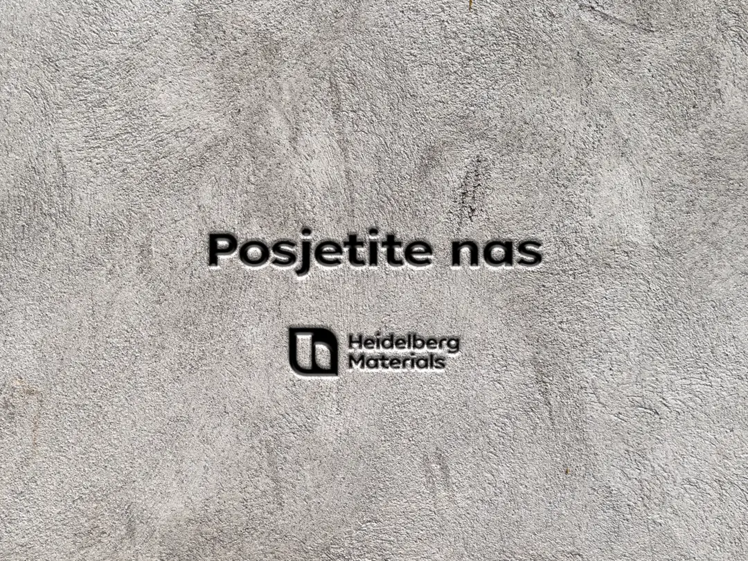 u betonu ugravirana slova Posjetite nas i logo Heidelberg Materials